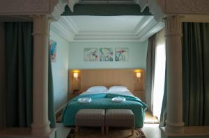 马拉喀什阿尔巴亚宫殿酒店的一间卧室配有一张带两把椅子的绿色床
