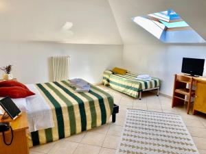 博尔焦韦雷齐Albergo Villa Ada的一间卧室设有两张床、一台电视和一扇窗户。