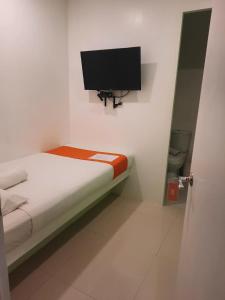麦克坦Islands Stay Hotels Mactan的一间小卧室,配有一张床和一台平面电视