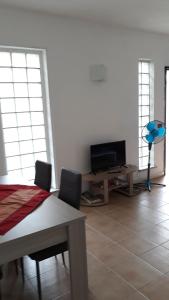 西尼斯科拉La Tanca的客厅配有电视和桌椅