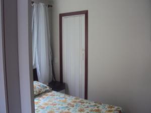 里约热内卢里约塔夸拉甜蜜民宿的卧室配有一张床,门旁设有镜子