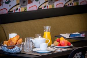 图尔Ferdinand Hotel Tours的一张桌子,上面放着一盘食物和一篮水果