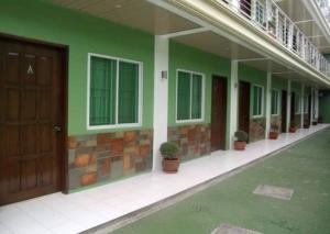 那牙Reddoorz @ Sta Cruz Naga City的一座建筑,上面有绿色的墙壁和盆栽植物