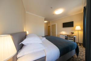 维尔扬迪亚撒旅馆的配有白色枕头的床的酒店客房