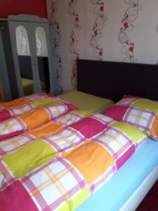 滨湖克拉科Zimmer und Apartment Rosi的卧室内的两张床和彩色毯子