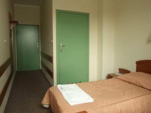 克拉科夫神圣之家旅馆的一间设有床铺和绿门的房间