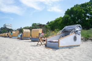 蒂门多弗施特兰德Schlafstrandkorb Nr. 4的沙滩上的一排沙滩小屋