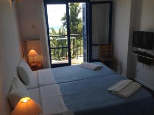 阿基奥斯基利考斯玛丽亚埃莱娜酒店的一间卧室设有一张大床和一个窗户。