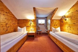 米滕瓦尔德桑嫩海姆宾馆的木墙客房的两张床