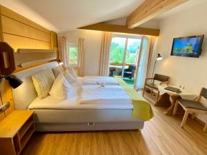 雷特温克尔Hotel Bichlhof的酒店客房设有一张大床和一张书桌。