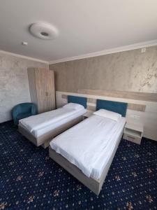 特尔古穆列什Vila El Passo的两张位于酒店客房的床,配有两张sidx sidx单人床