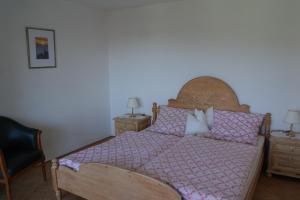 RingelaiFerienhaus Bayerwald的一间卧室配有一张带木制床头板和枕头的床。