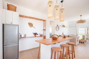卡尔扎迈纳Alta Vista Luxury House的厨房配有冰箱和带凳子的桌子