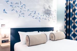 巴黎Hôtel Bleu de Grenelle的一间卧室,卧室里配有一张床,鸟儿飞翔在空中