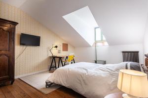 克卢尼La maison des couturières的卧室配有一张床,墙上配有电视。