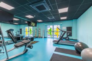 迭戈姆布鲁塞尔机场托恩酒店的一间健身房,内设健身器材,位于带蓝色墙壁的房间