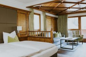 格罗萨尔Hotel Tauernhof的一间卧室配有一张床、一张沙发和一张桌子