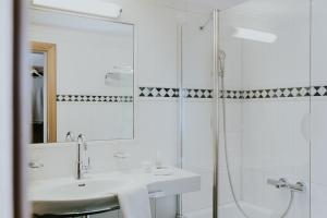 格罗萨尔Hotel Tauernhof的白色的浴室设有水槽和淋浴。