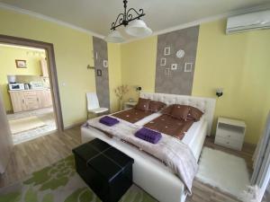 埃格尔Eszter Apartman的卧室配有一张带紫色枕头的大型白色床。