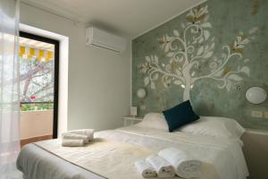 坎普码头Hotel Punto Verde的卧室墙上挂着树壁画