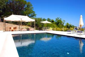 格拉达拉Villa Francesca Relais的一个带蓝色水和遮阳伞的游泳池