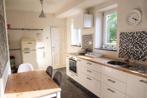 德哈恩Heart at Sea - De Haan的厨房配有白色橱柜、桌子和水槽。