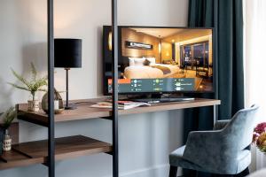 海牙Boutique Hotel First City的一张桌子上配有电视的房间,一张床铺