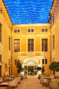 尼姆Margaret - Hôtel Chouleur的一座带蓝色天花板和灯的大建筑