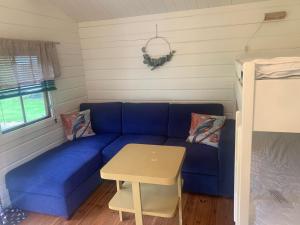 瓦尔河谷瓦尔达尔露营地的一张蓝色的沙发,位于带桌子的房间