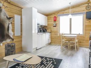 萨利色尔卡Holiday Home Poromies b by Interhome的一间厨房和带木墙及桌子的用餐室