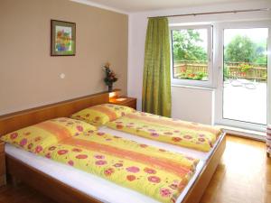 OberwangHoliday Home Mayrhofer - MON240 by Interhome的一间卧室配有一张带黄色棉被的床和窗户