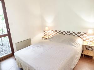 拉卡诺奥肯Holiday Home Les As-9 by Interhome的卧室配有白色的床和两张台灯。