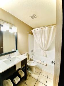 怀俄明Super 8 Grand Rapids City Center的浴室配有盥洗盆、卫生间和浴缸。