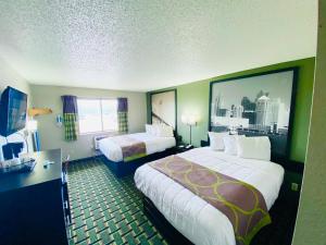 怀俄明Super 8 Grand Rapids City Center的酒店客房设有两张床和大窗户。