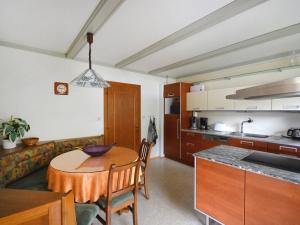 拉登泰因科夫勒拉登腾度假屋的厨房以及带桌子、厨房和桌椅的用餐室。