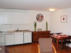 南达丘尔杜迪波尔四内达兹站公寓的厨房配有桌子和墙上的时钟