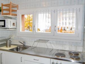 南达南达站格内4号公寓的厨房配有白色橱柜和水槽