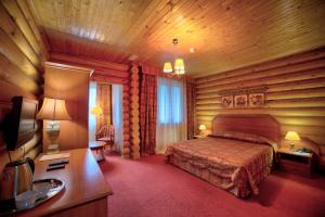 ShaldovoHotel Semigorie的卧室配有一张床铺,位于带木墙的房间内