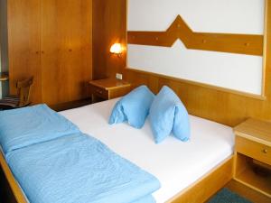 索尔登Apartment Alpenblick - SOE750 by Interhome的一间卧室配有一张带蓝色枕头的床。