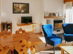 南达姆沃瑞斯公寓I B1的客厅配有木桌和蓝色椅子