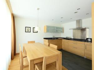 采尔马特Apartment Zur Matte B-4 by Interhome的厨房配有木桌和厨房台面