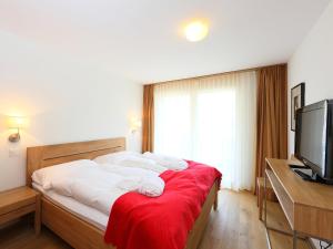 采尔马特Apartment Zur Matte B-7 by Interhome的一间卧室配有一张带白色床单的床和电视。