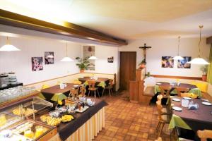 巴比亚诺Garni Kircher Sepp的一间带桌椅的餐厅以及一间自助餐