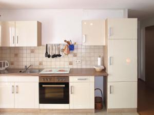 BrendenApartment Alpenblick by Interhome的厨房配有白色橱柜和炉灶烤箱。