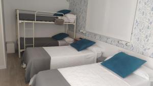 波尔托马林PortoSantiago的客房配有两张带蓝色枕头的床。