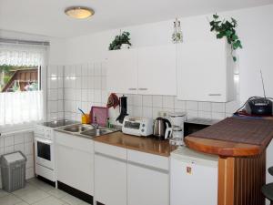 BuchholzHoliday Home Zum Blauen Pfau by Interhome的厨房配有白色橱柜和水槽
