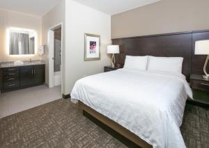 普莱诺Staybridge Suites Plano - Richardson Area, an IHG Hotel的酒店客房设有一张大床和一间浴室。