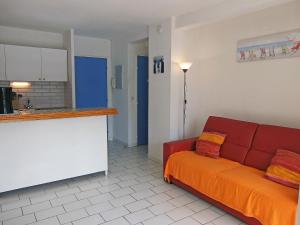 Plage dʼArgelès圣玛丽亚公寓的一间带红色沙发的客厅和一间厨房