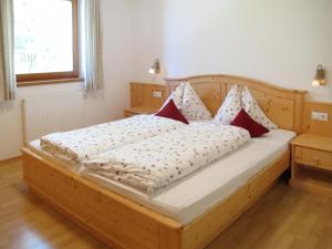 马兰扎Apartment Obermüllerhof-1 by Interhome的一张带红色和白色枕头的木床