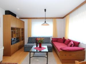 Flaurling哈格勒公寓的客厅配有红色的沙发和桌子